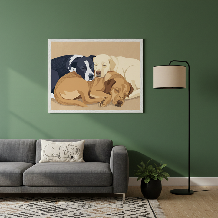 Modern living room with a grey sofa and a black floor lamp. A large white-framed illustration of three sleeping dogs (black & white, light brown, yellow lab) hangs centered above the sofa on a green wall.