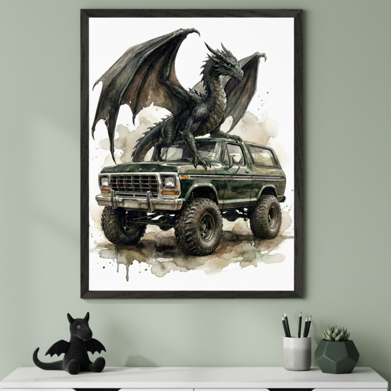 Modern room with a sage green wall and white dresser. A large framed watercolor print of a dark green off-road Ford Bronco with a black dragon perched on top hangs above the dresser. A black dragon plush sits on the dresser.