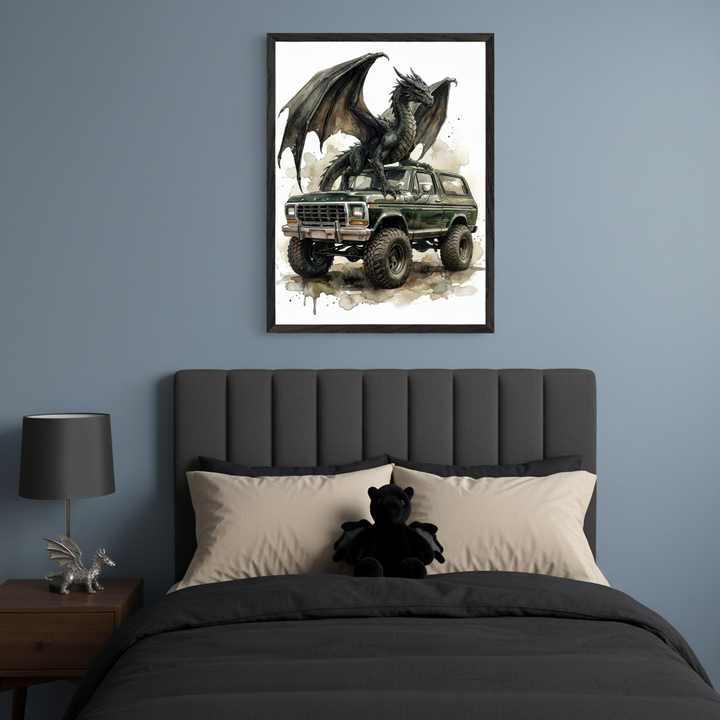 Modern bedroom with a dark gray upholstered bed and black bedding. A black bat plush sits on light beige pillows. On the left, a dark wooden nightstand holds a black lamp and a silver dragon figurine. Above the bed, a black-framed watercolor print depicts a black dragon on a green Ford Bronco.