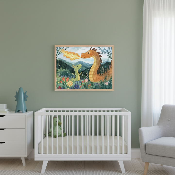 Modern nursery with sage green walls. A framed watercolor-style illustration of an orange adult dragon breathing fire next to a green baby dragon in a flower field hangs centered above a white crib. A white dresser and a gray armchair are also visible.