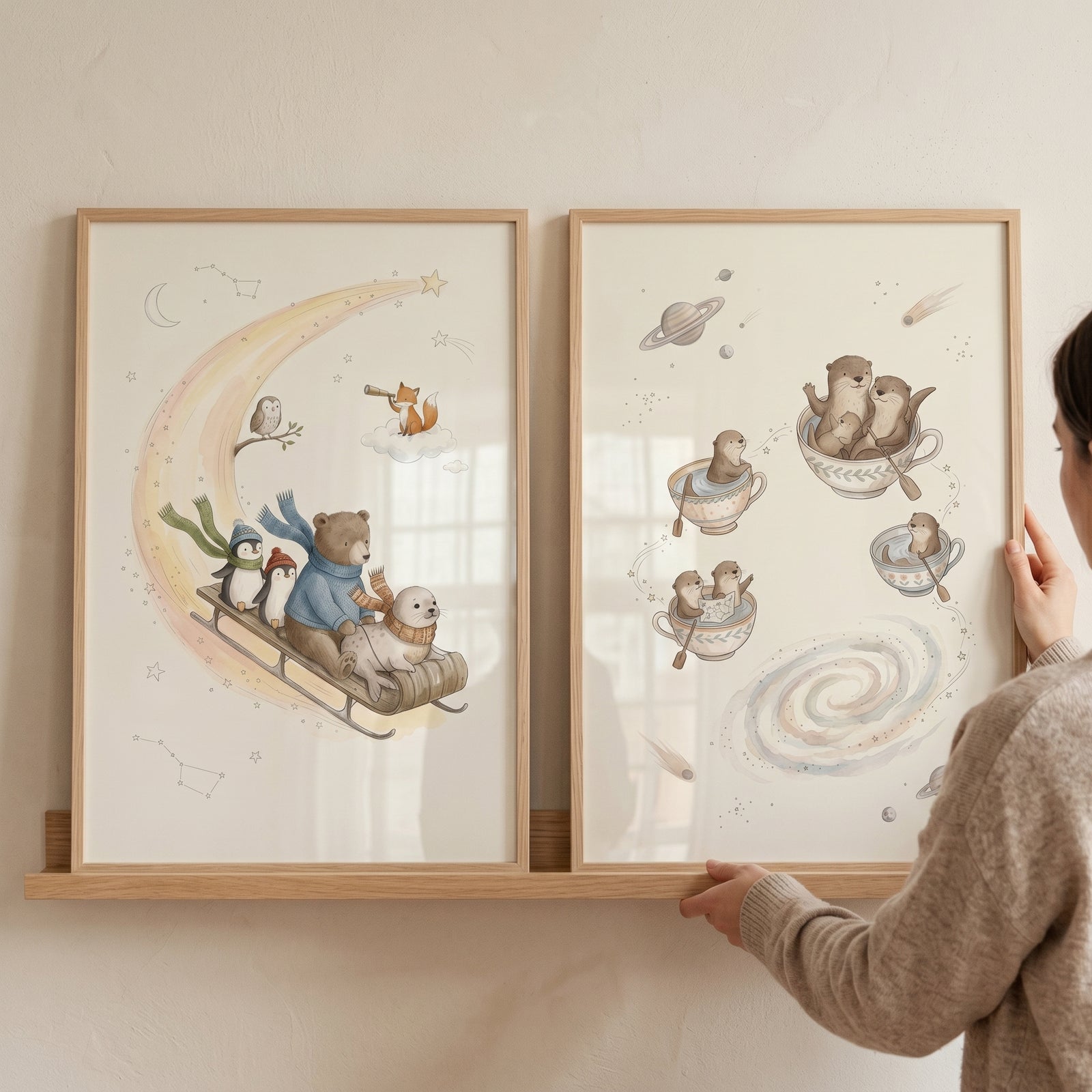 Dreamy celestial animals wall art set of 2 showing watercolor prints of animals on a moon and otters in teacups.