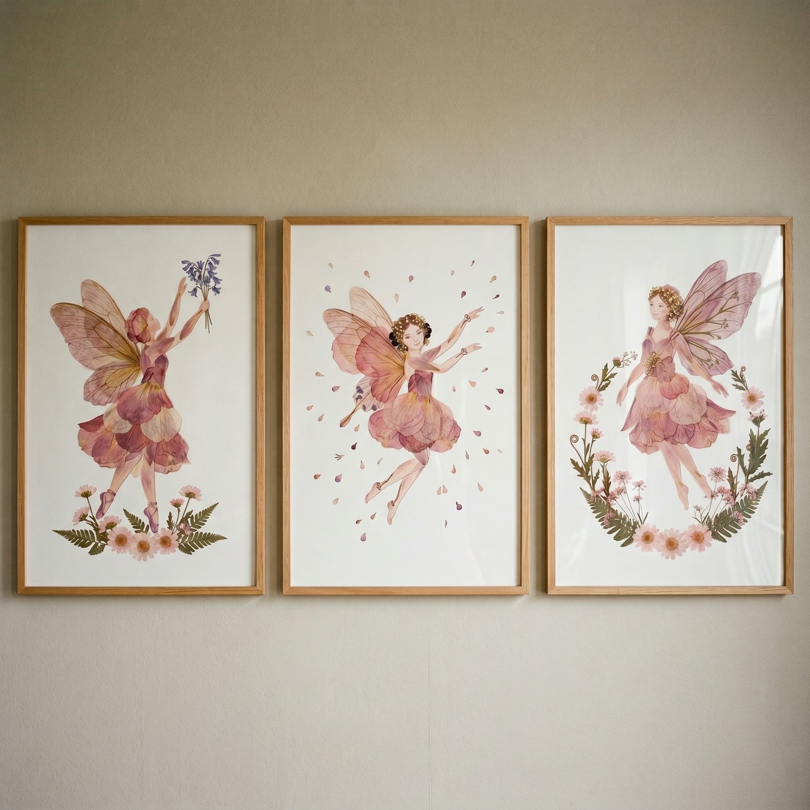 Dreamy garden petal fairy wall art set of 3 in wood frames with whimsical floral-winged figures on a neutral wall.