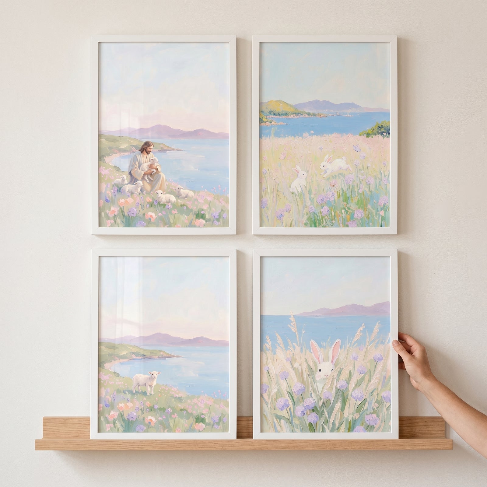 Hand adjusts a dreamy pastel meadow coastal wall art set of 4 featuring Jesus, sheep, and rabbits on a wooden shelf.