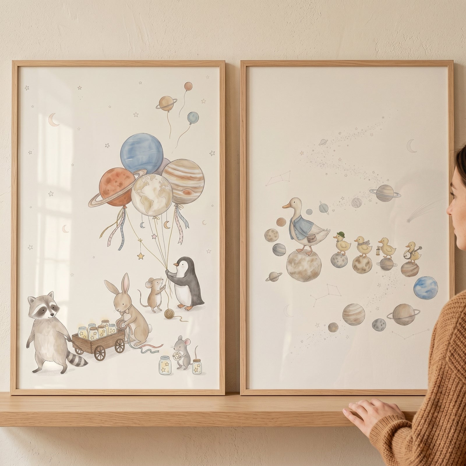 A dreamy pastel space animals wall art set of 2 featuring watercolor animals and planets in light wood frames.