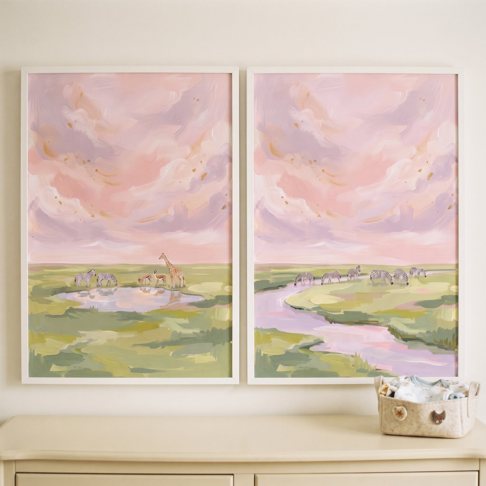 Dreamy pink sky zebra animals wall art set of 2 shows zebras and a giraffe by water under soft pink and purple clouds.