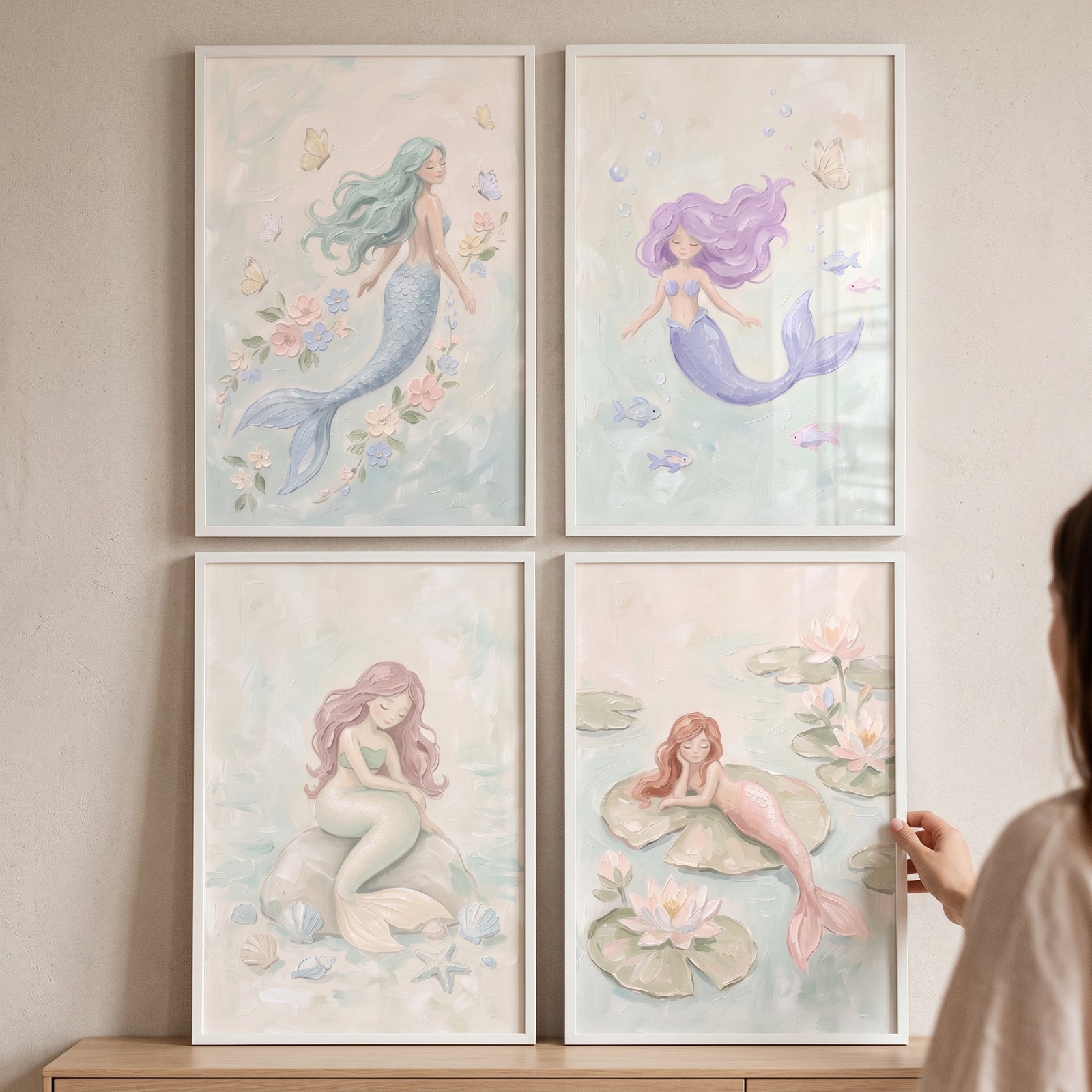 Dreamy whimsical pastel mermaid wall art set of 4 in white frames arranged in a grid on a soft beige wall.