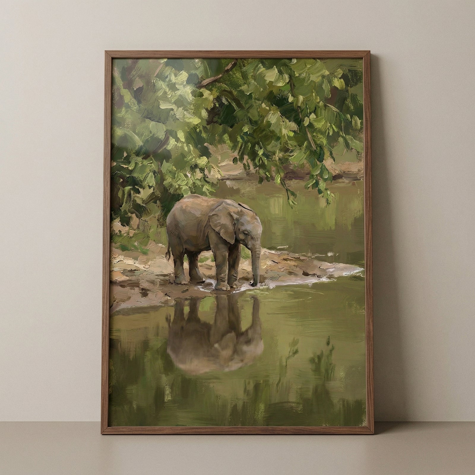 A framed vertical artwork featuring a small elephant calf at the edge of a tranquil body of water. The scene is lush, with dense green foliage and tree branches hanging over the water's surface from above. 