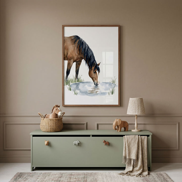 Drinking water brown horse wall art hangs above a green toy chest with animal knobs, a lamp, and a wooden elephant.