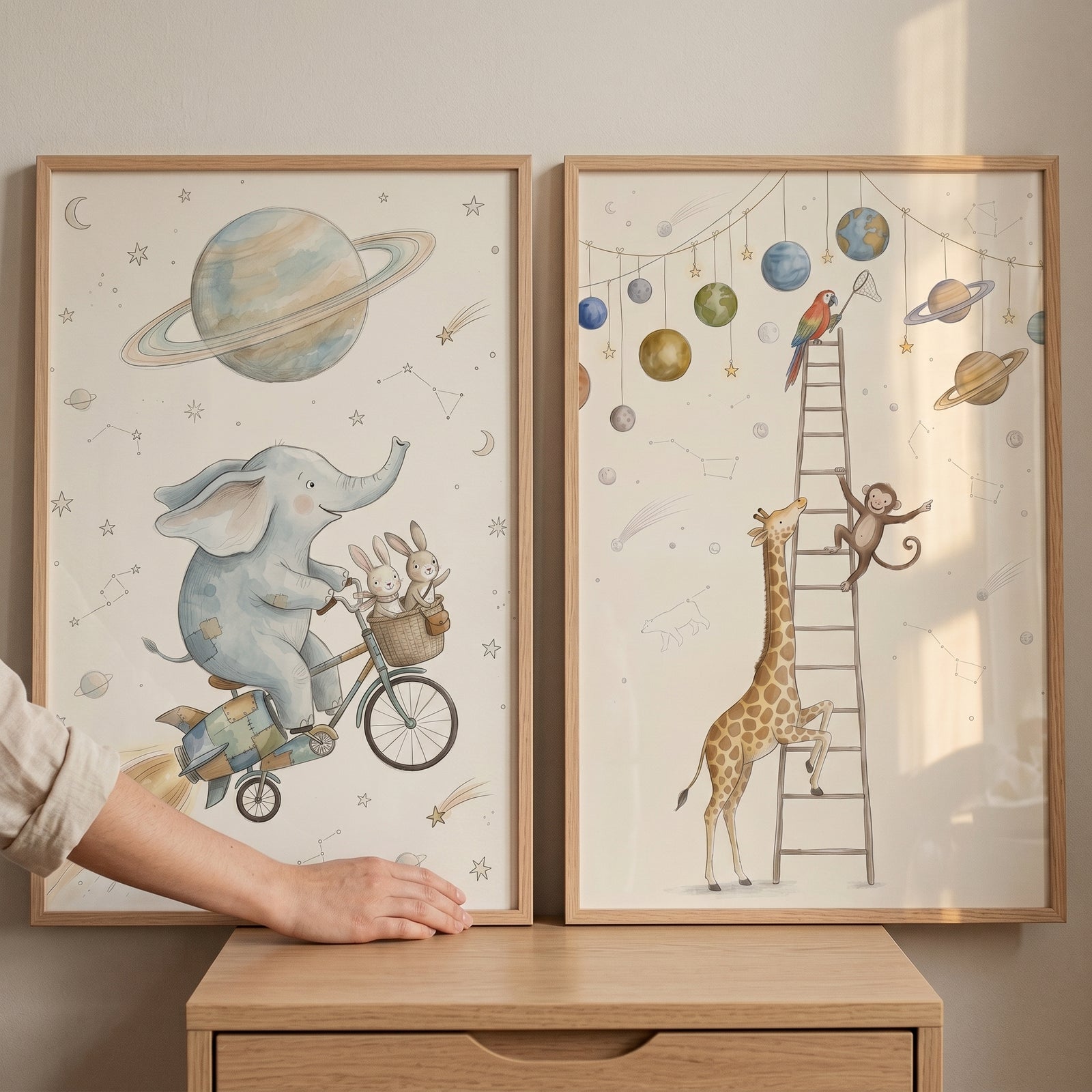 Dusty blue celestial animals wall art set of 2 shows an elephant on a bike and a giraffe climbing toward hanging planets.
