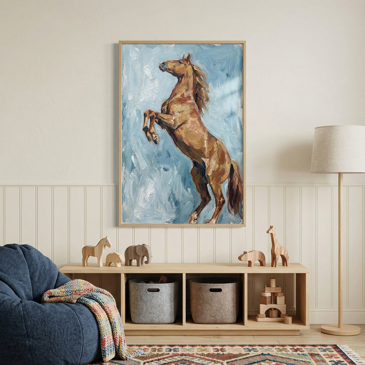 This image features a framed artwork on a light-colored wall, depicting a majestic brown horse reared up on its hind legs. The artwork is created with thick, expressive brushstrokes in shades of brown and tan for the horse, set against a textured background of light blue and white.
