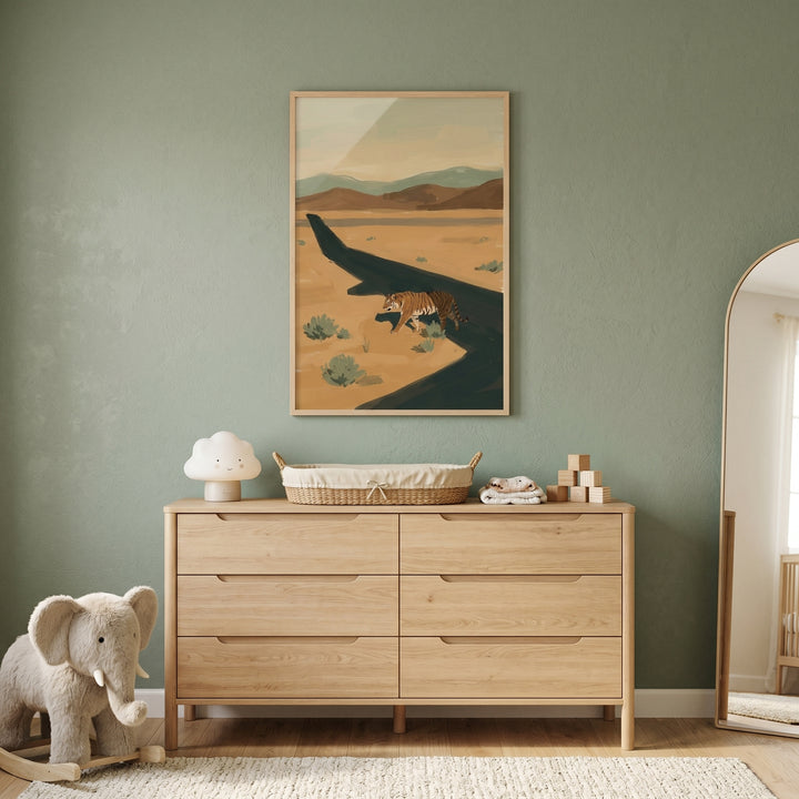 Earth tone landscape tiger wall art above a light wood dresser with a cloud lamp, basket, mirror, and plush elephant.