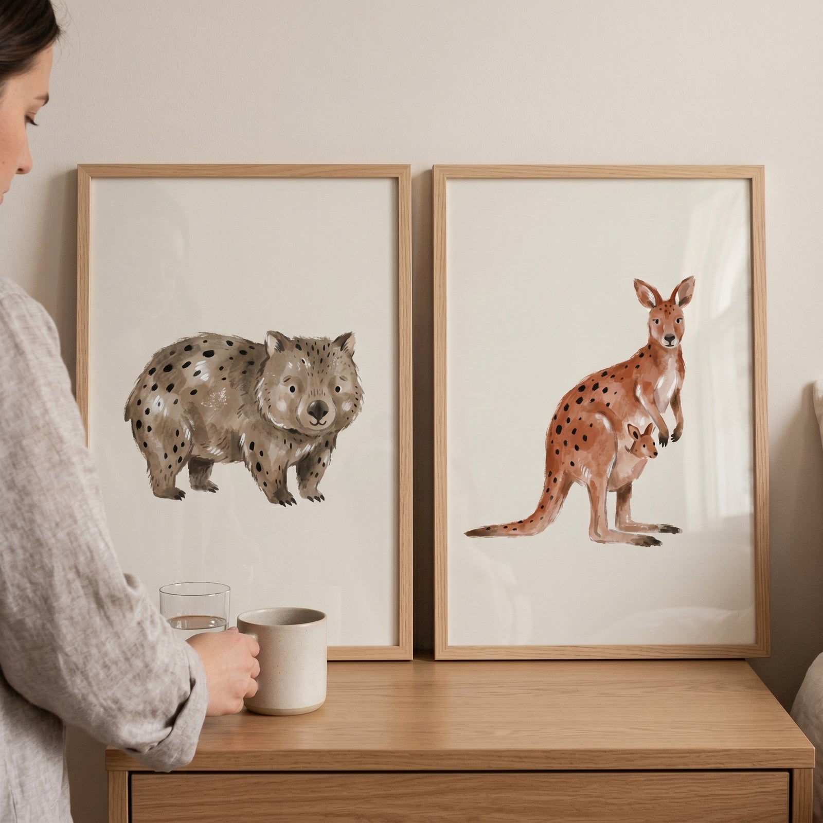 Earthy neutral australian animals wall art set of 2 featuring a spotted wombat and kangaroo with a joey on a dresser.