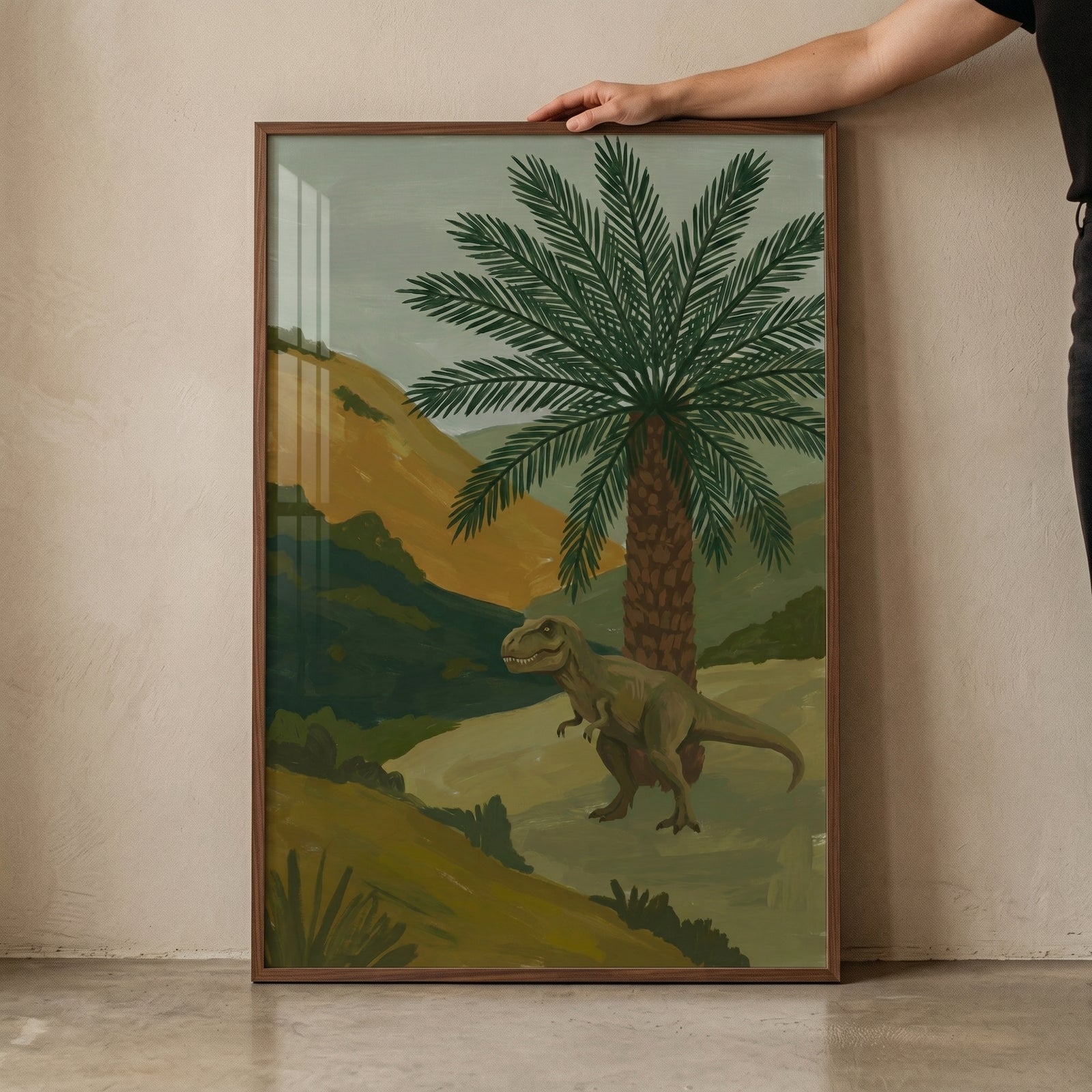 Framed earthy palm tree t-rex wall art featuring a green dinosaur, a tall palm tree, and rolling hills.