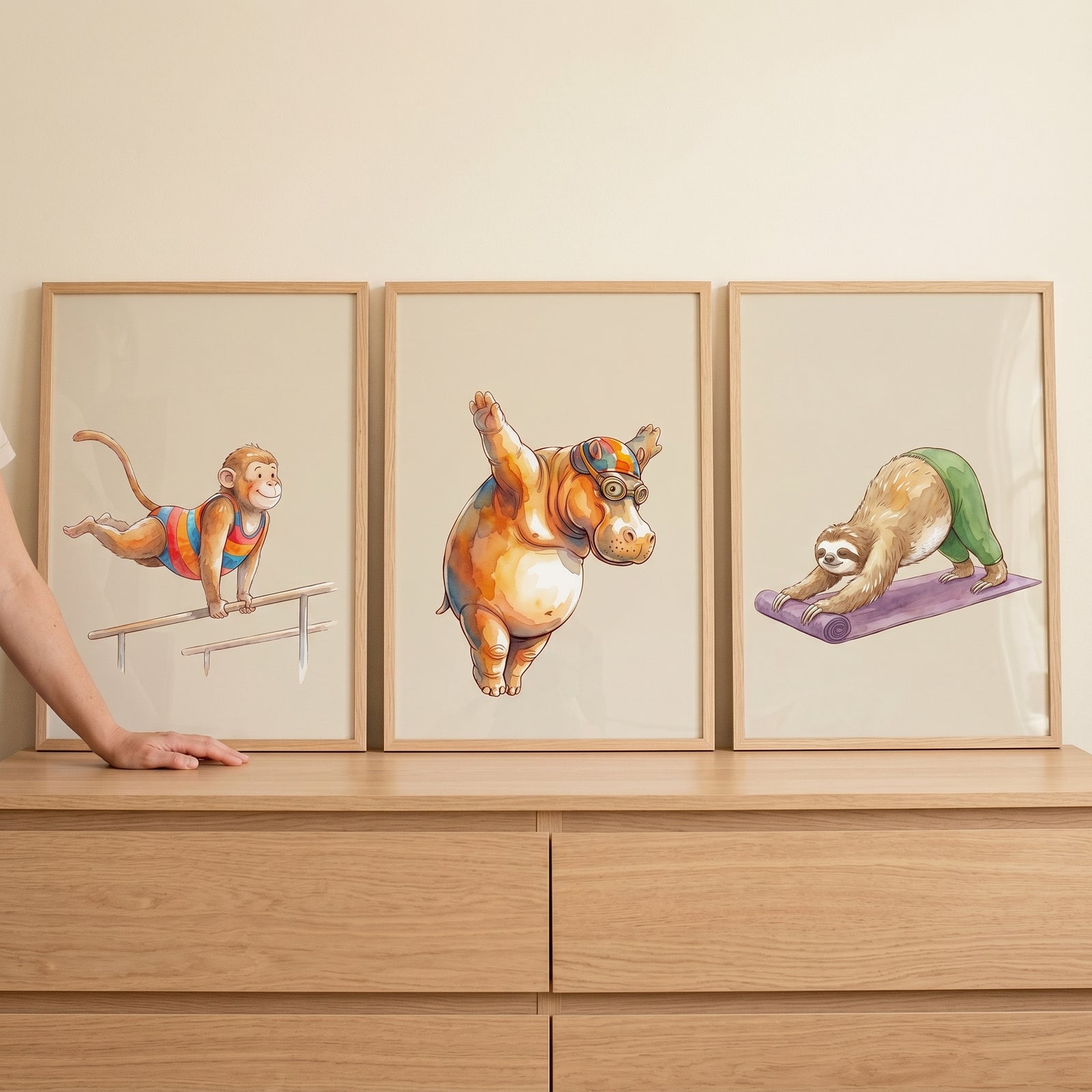 Earthy sports animals wall art set of 3 featuring a gymnastic monkey, diving hippo, and yoga sloth on a dresser.