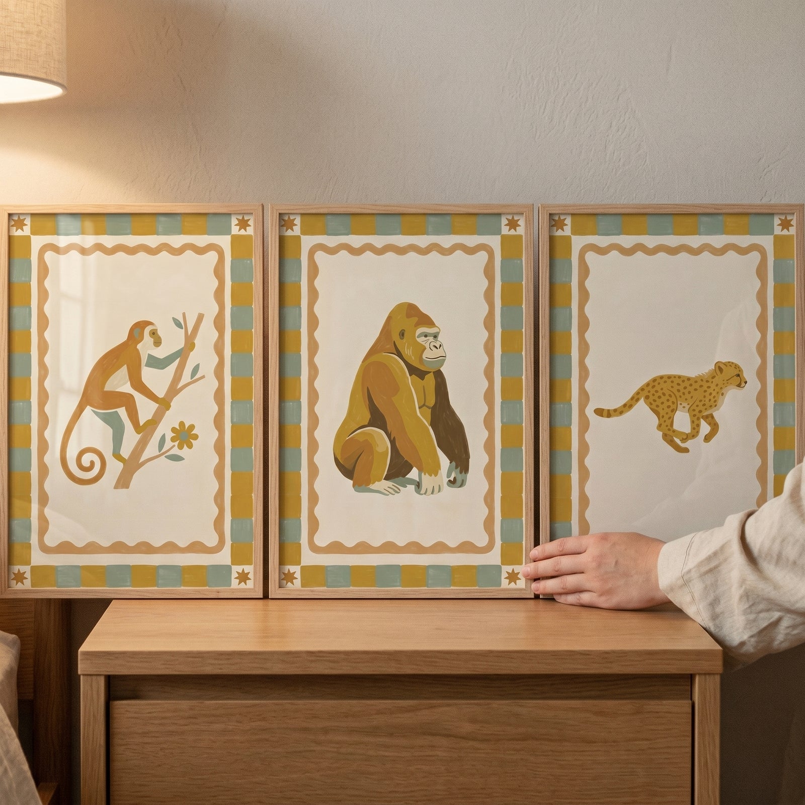 Earthy star safari animal wall art set of 3 featuring a monkey, gorilla, and cheetah in wood frames on a dresser.
