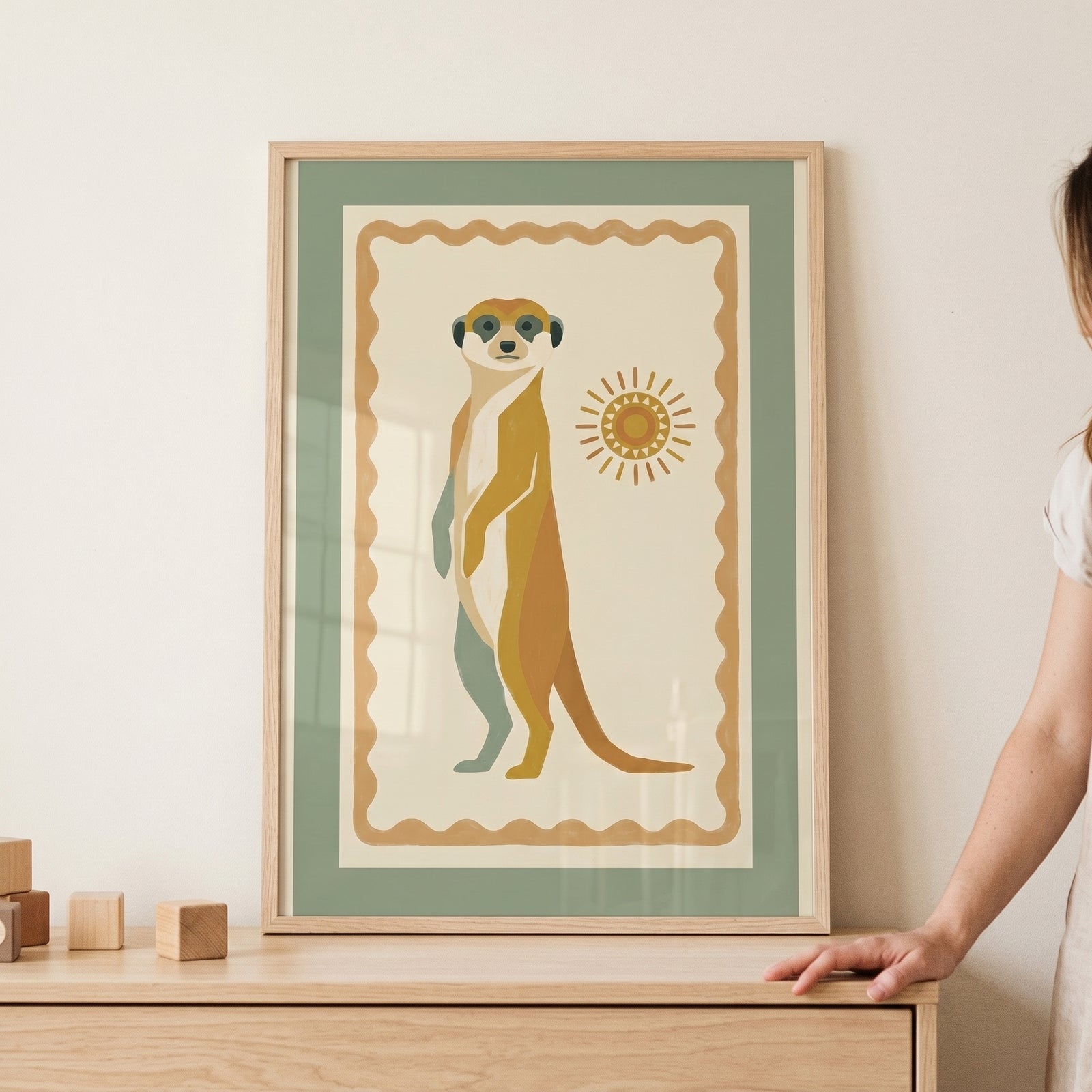 Earthy sun folk meerkat wall art in a wooden frame features a stylized animal in muted sage green and ochre tones.
