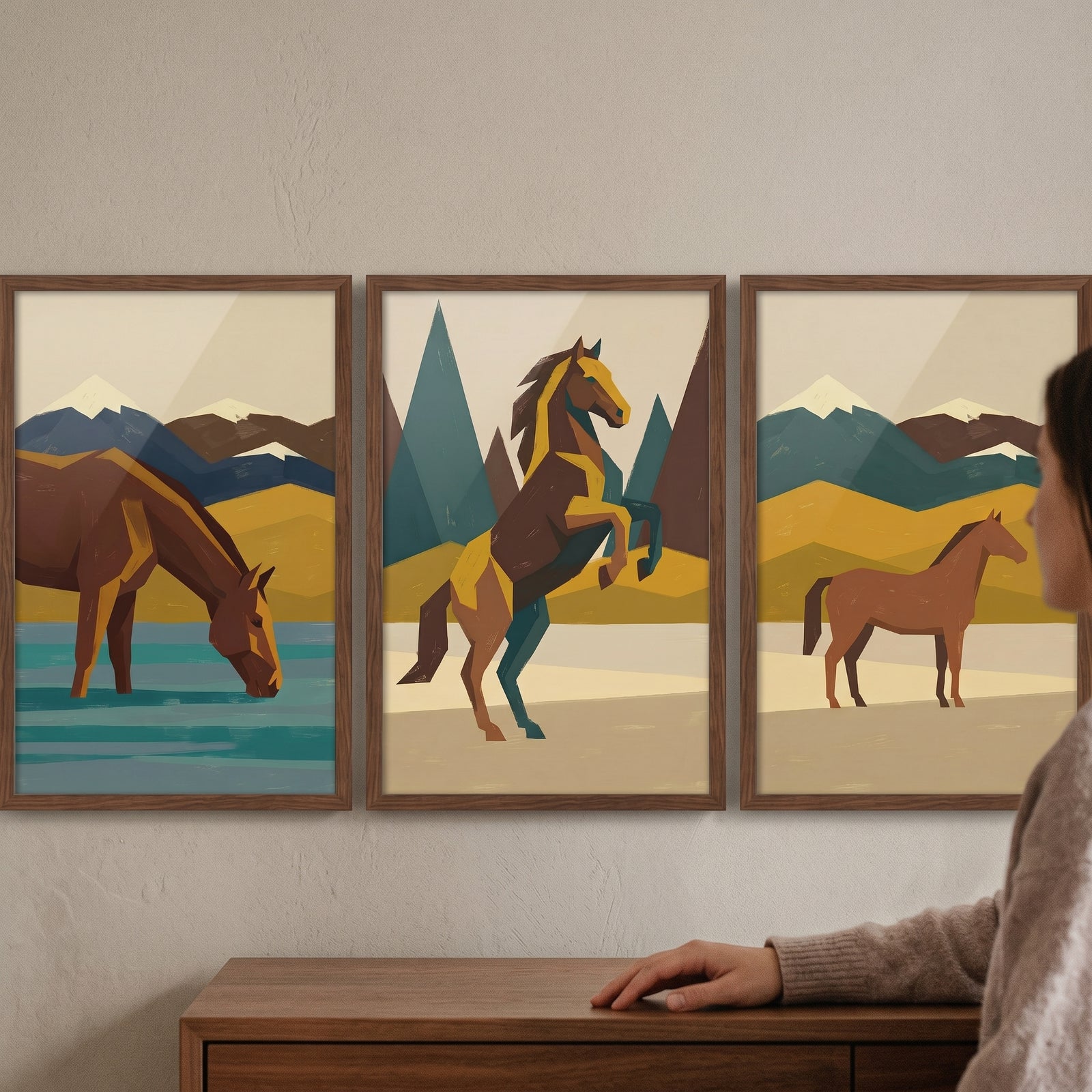 Earthy tone mountain horse artwork set of 3 shows horses in geometric mountain landscapes above a wooden dresser.