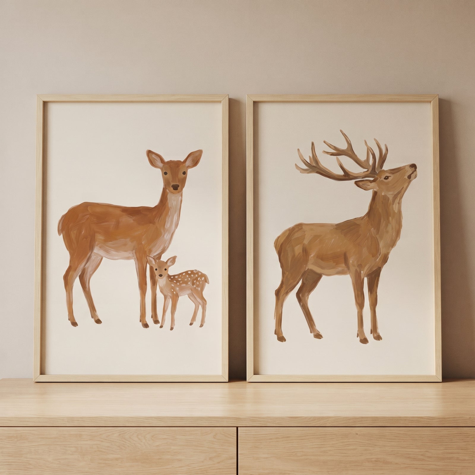 Earthy tone woodland deer wall art set of 2 features a doe with her fawn and a large stag in light wood frames.