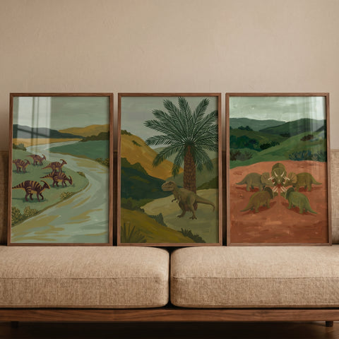 Earthy tones landscape dinosaur wall art set of 3 depicting various dinosaurs in nature scenes displayed on a sofa.