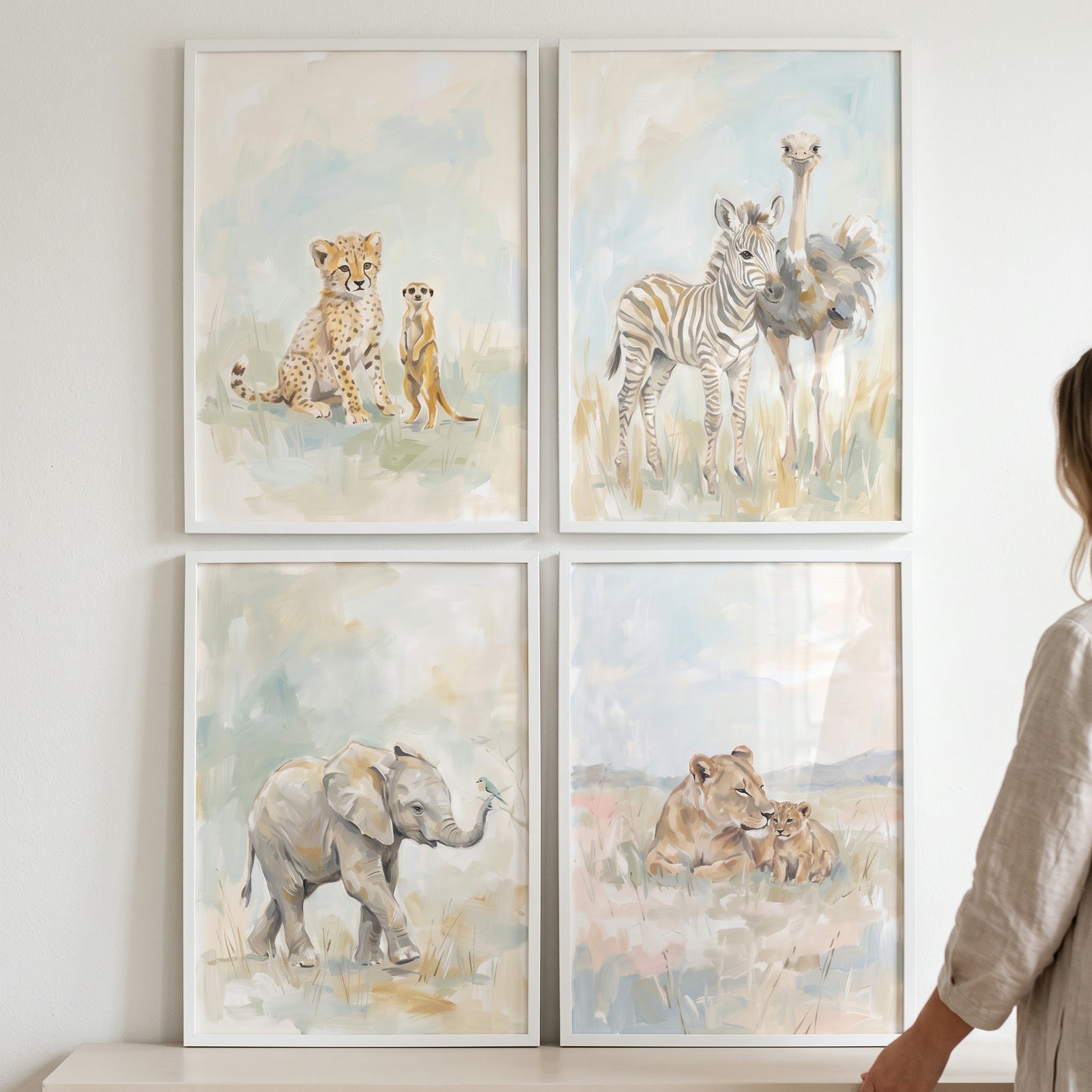 Earthy watercolor safari animals print set of 4 with a cheetah, meerkat, zebra, ostrich, elephant, and lions in white frames.