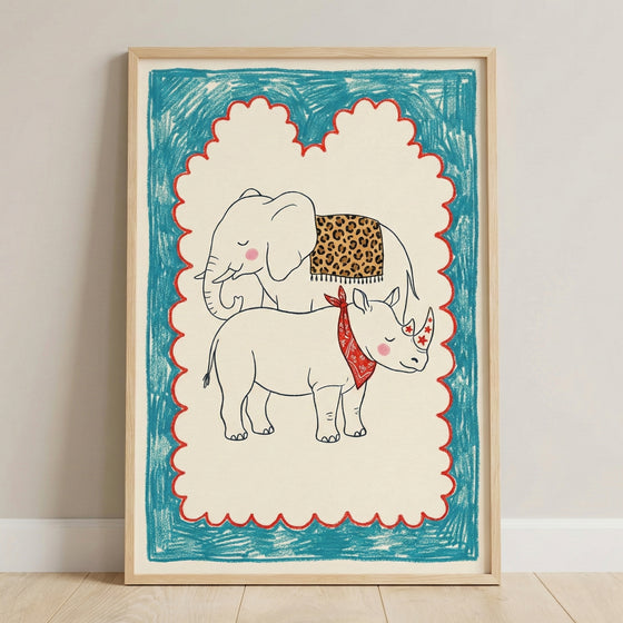 Framed illustration of a smiling baby elephant and baby rhino, with the elephant wearing a leopard-print blanket and the rhino in a red bandana and star stickers on its horn. The playful drawing is bordered by a scalloped red and blue crayon-style frame.