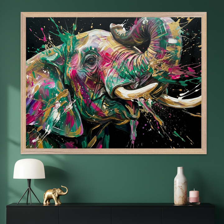 Modern room with a large, light wood framed, colorful abstract elephant painting in a splatter style hanging above a black console table. A white lamp, a gold elephant figurine, a marble vase, and a pink candle decorate the table.