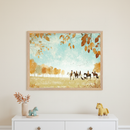 Kid's room with a white dresser. A large framed illustration of horse riders and dogs in an autumn landscape hangs above the dresser. A vase with dried leaves and two horse figurines are on the dresser.