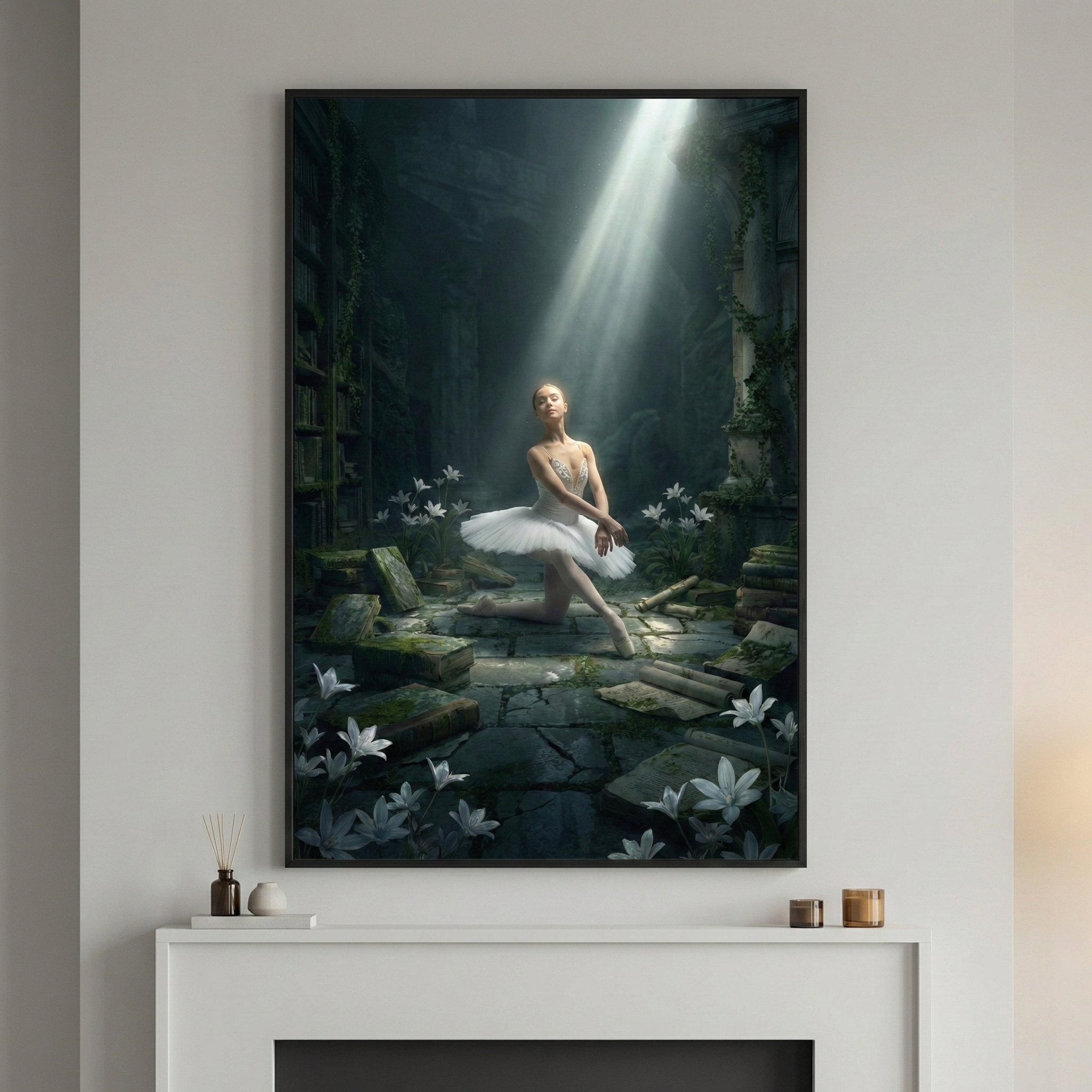 A framed piece of digital art hangs above a white fireplace mantel. The artwork depicts a ballerina in a white tutu, illuminated by a single, dramatic beam of light from above. She is positioned in a dark, atmospheric, and overgrown stone chamber filled with scattered books, stone blocks, and white lilies. The room is partially reclaimed by nature, with vines and moss on the walls. On the mantel below are a small vase with reeds, a white bowl, and two small candles.