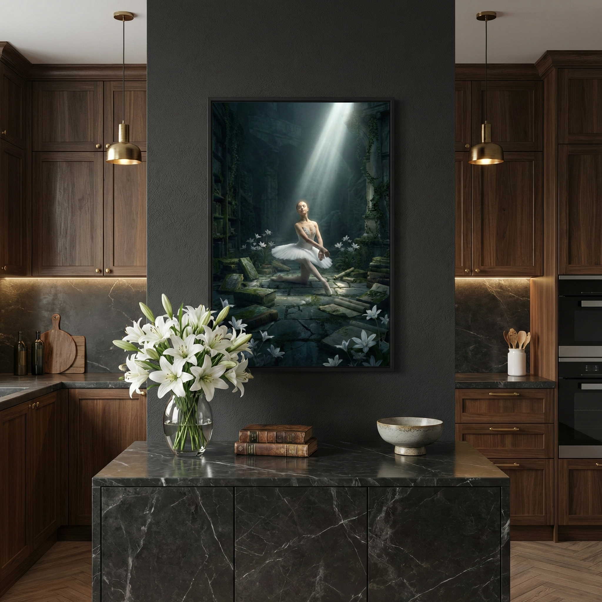 A sophisticated kitchen features dark wood cabinetry and gold pendant lights. Centered on a dark grey wall is a large framed artwork showing a ballerina in a white tutu, illuminated by a beam of light in a mysterious, overgrown forest setting. Below the frame, on a black marble-topped island, sit a vase of white lilies, a stack of vintage books, and a ceramic bowl. The scene is moody and elegant, with light-toned herringbone wood flooring visible at the bottom.