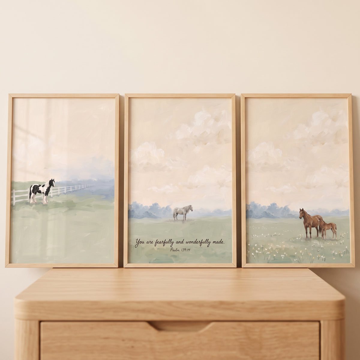 Ethereal meadow scene horse wall art set of 3 with horses and Psalm 139:14 in light wood frames on a dresser.