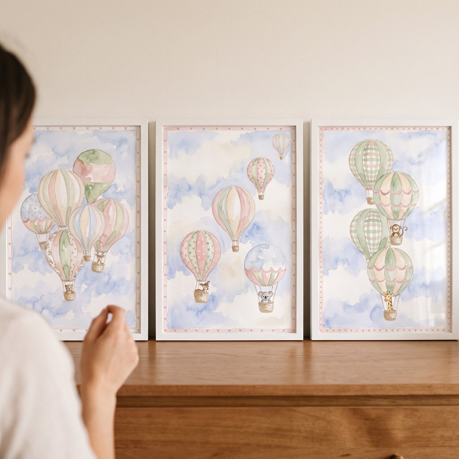 Ethereal sky balloon animal wall art set of 3 in white frames showing pastel balloons and animals on a wooden dresser.