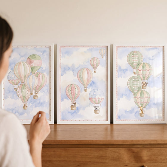 Ethereal sky balloon animal wall art set of 3 in white frames showing pastel balloons and animals on a wooden dresser.
