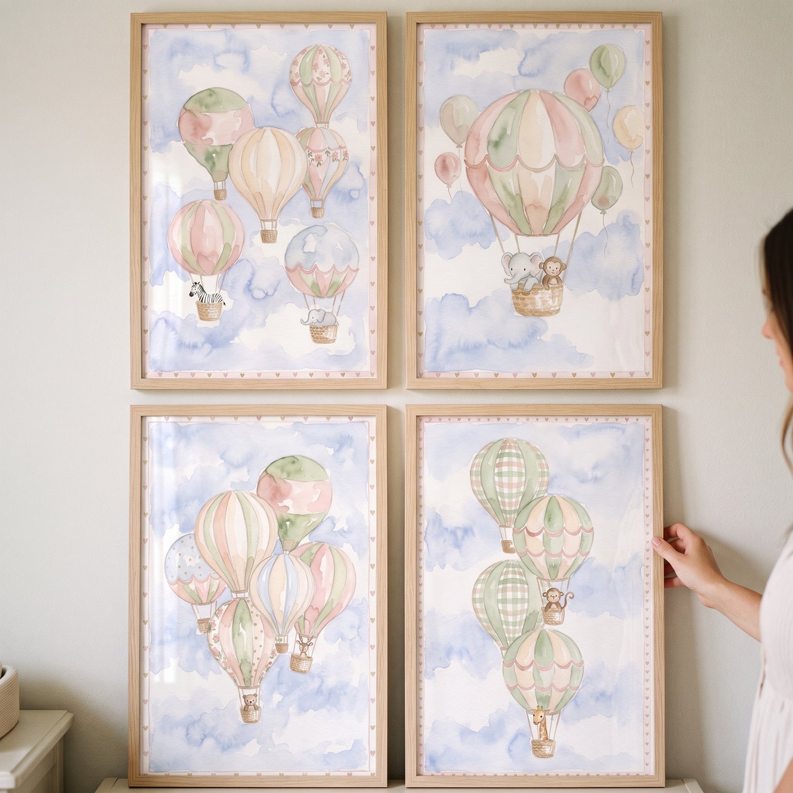 Ethereal sky safari animal wall art set of 4 with watercolor hot air balloons and animals in a blue cloud-filled sky.