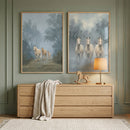 Two framed horse prints hang above a light wood dresser against a muted green paneled wall. One print shows three pale horses walking along a misty forest path, while the other shows three white horses standing side by side in a soft blue gray landscape, styled with a table lamp, rocking horse, and draped knit blanket below.
