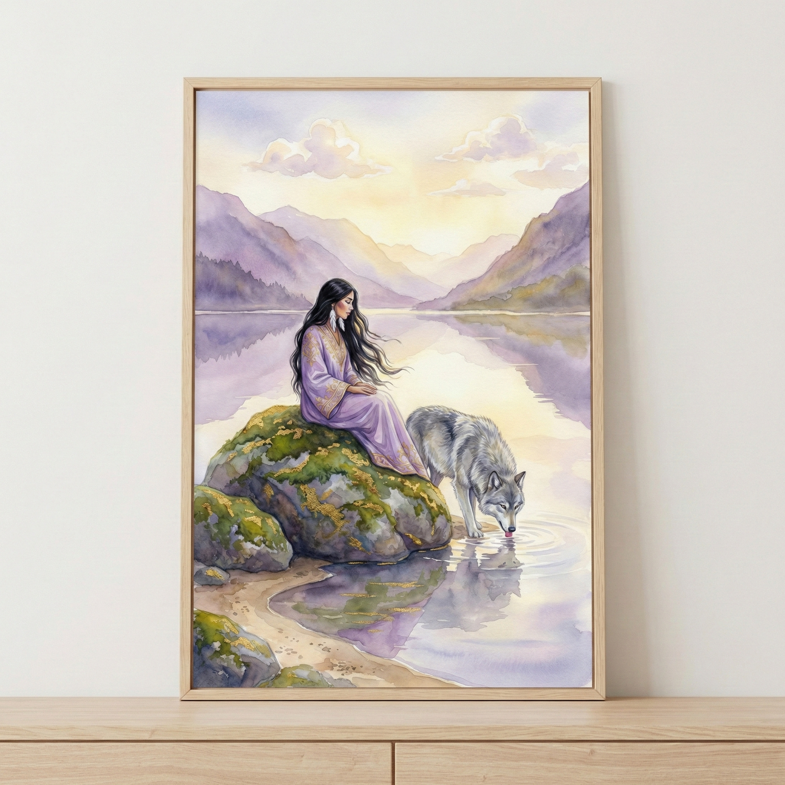 A framed painting depicts a serene scene with a woman in a flowing lavender dress sitting on a moss-covered rock by a tranquil lake. Beside her, a wolf drinks from the water, creating gentle ripples. The background features soft, pastel-colored mountains under a cloudy sky.