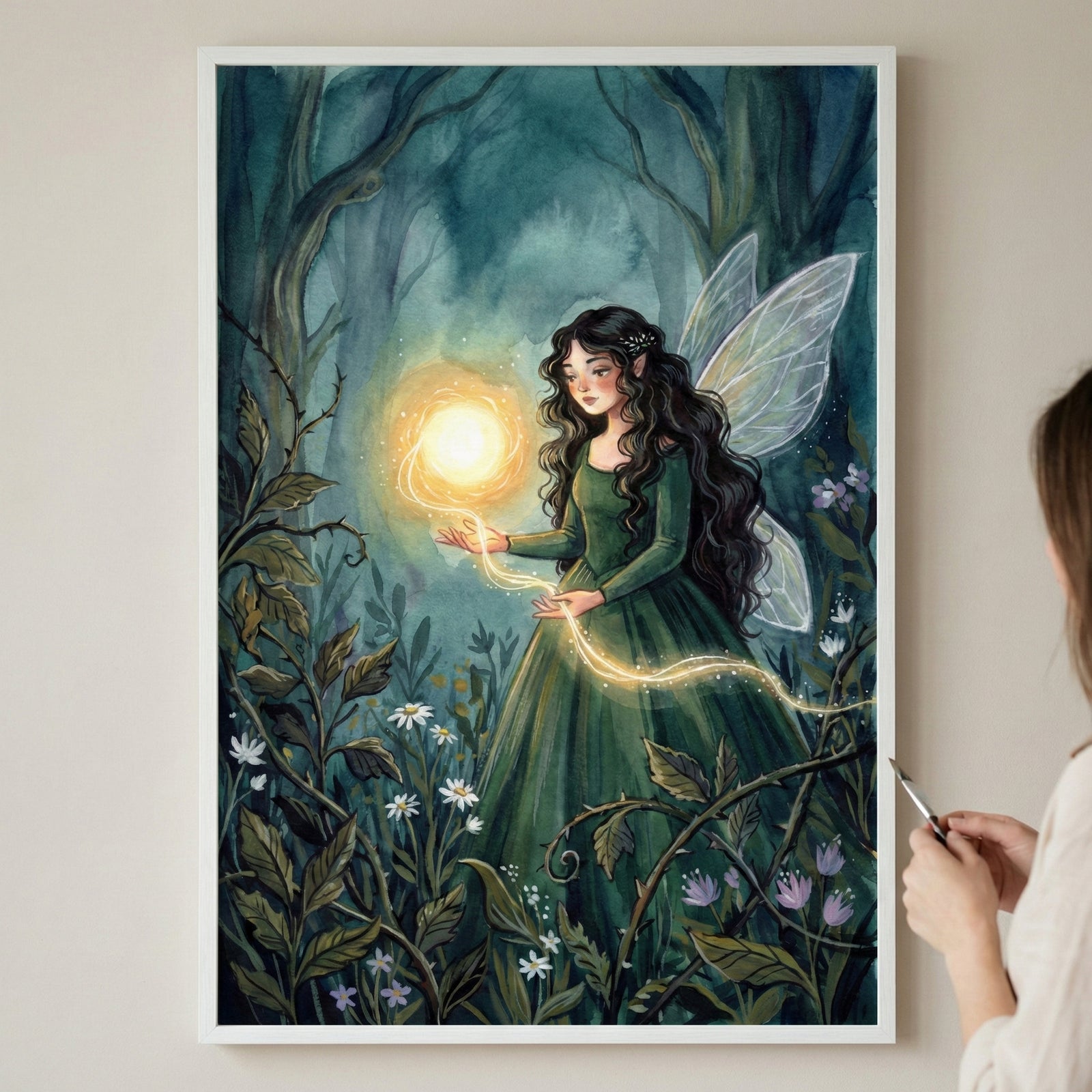 A framed illustration of a magical fairy with long, dark wavy hair and delicate wings, standing in an enchanted forest. She wears a flowing green dress and holds a glowing orb of light connected to a trail of golden sparkles. Wildflowers and lush foliage surround her as she radiates warmth and wonder.