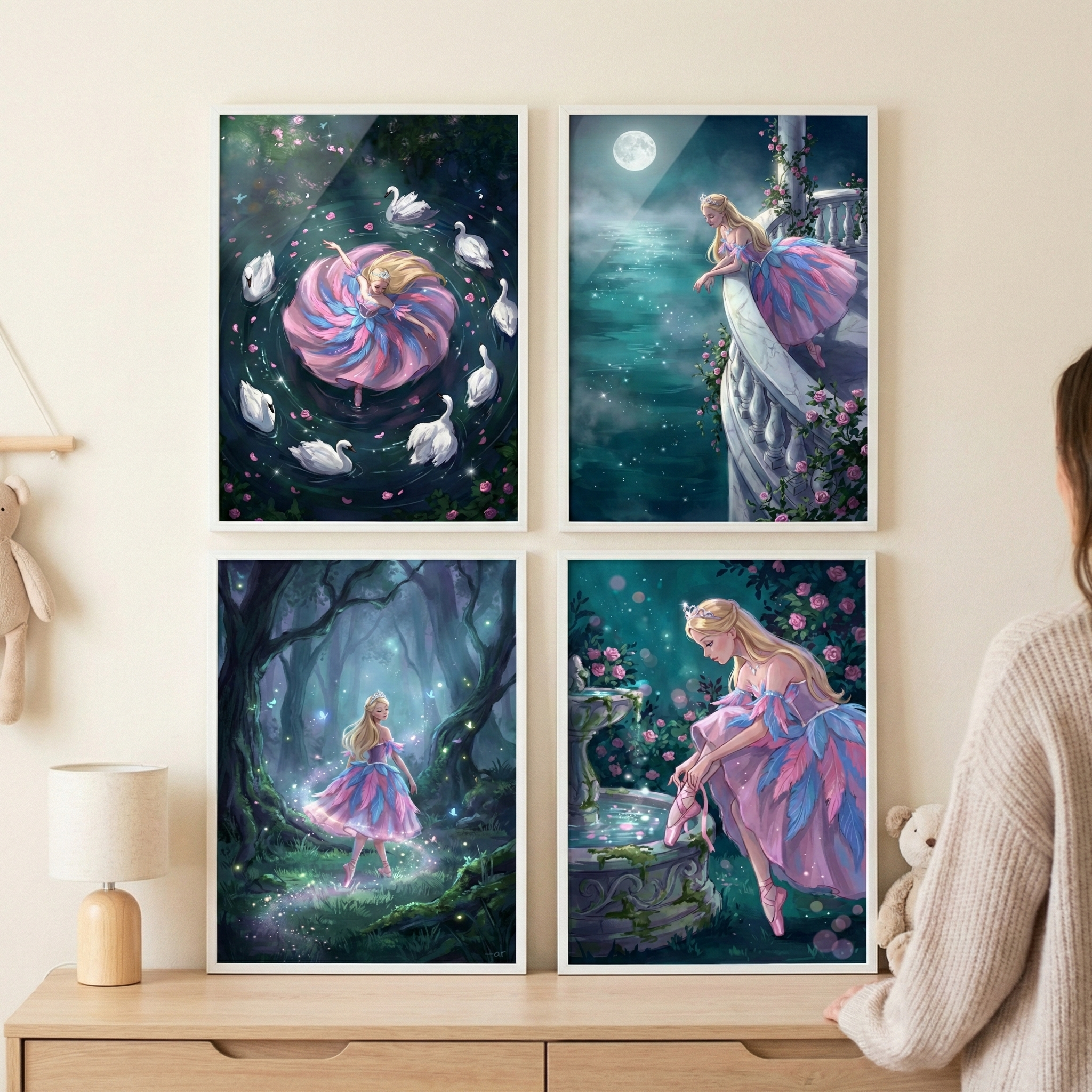 Four framed illustrations are displayed in a two-by-two grid on a neutral-toned wall above a wooden dresser. Each piece features a fair-haired woman in a voluminous, layered pink and blue dress, set within magical, nocturnal scenes.
In the top left frame, the woman spins in the center of a circle formed by white swans on a dark pond scattered with pink petals. The top right image shows her standing on a white stone balcony, looking out over a vast, misty sea illuminated by a large full moon.  