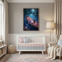 A serene nursery is decorated in soft gray, pink, and light blue tones. Centered against a light gray wall is a white wooden crib with a striped pink mattress cover and a light blue dust ruffle. Above the crib hangs a large framed vertical artwork. The illustration depicts a young blonde-haired girl in a whimsical pink and purple dress sitting in a small wooden boat filled with clusters of pink flowers. 