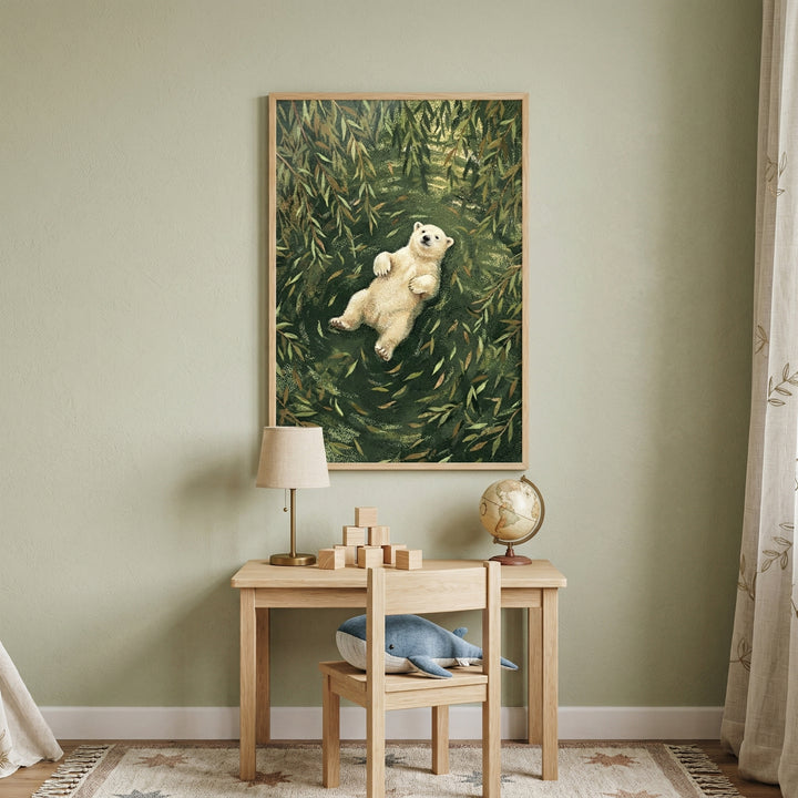 A serene child's study area features a sage green wall as a backdrop for a large framed illustration. The artwork depicts a fluffy white bear cub floating on its back in a pool of dark green water filled with willow leaves. Beneath the frame, a light wood desk holds a simple lamp, a collection of wooden blocks, and a small globe. A matching wooden chair has a plush blue and white whale toy resting on its seat. A star-patterned rug and an embroidered curtain complete the calm room.
