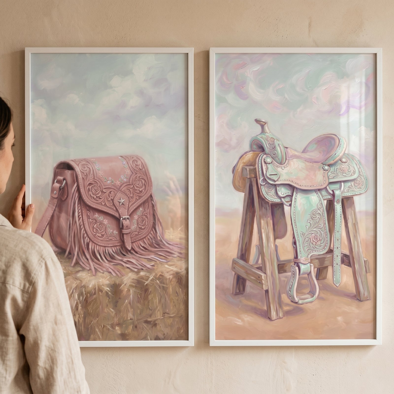 Floral pastel western wall art set of 2 featuring a pink fringed bag on hay and a colorful saddle on a wooden stand.