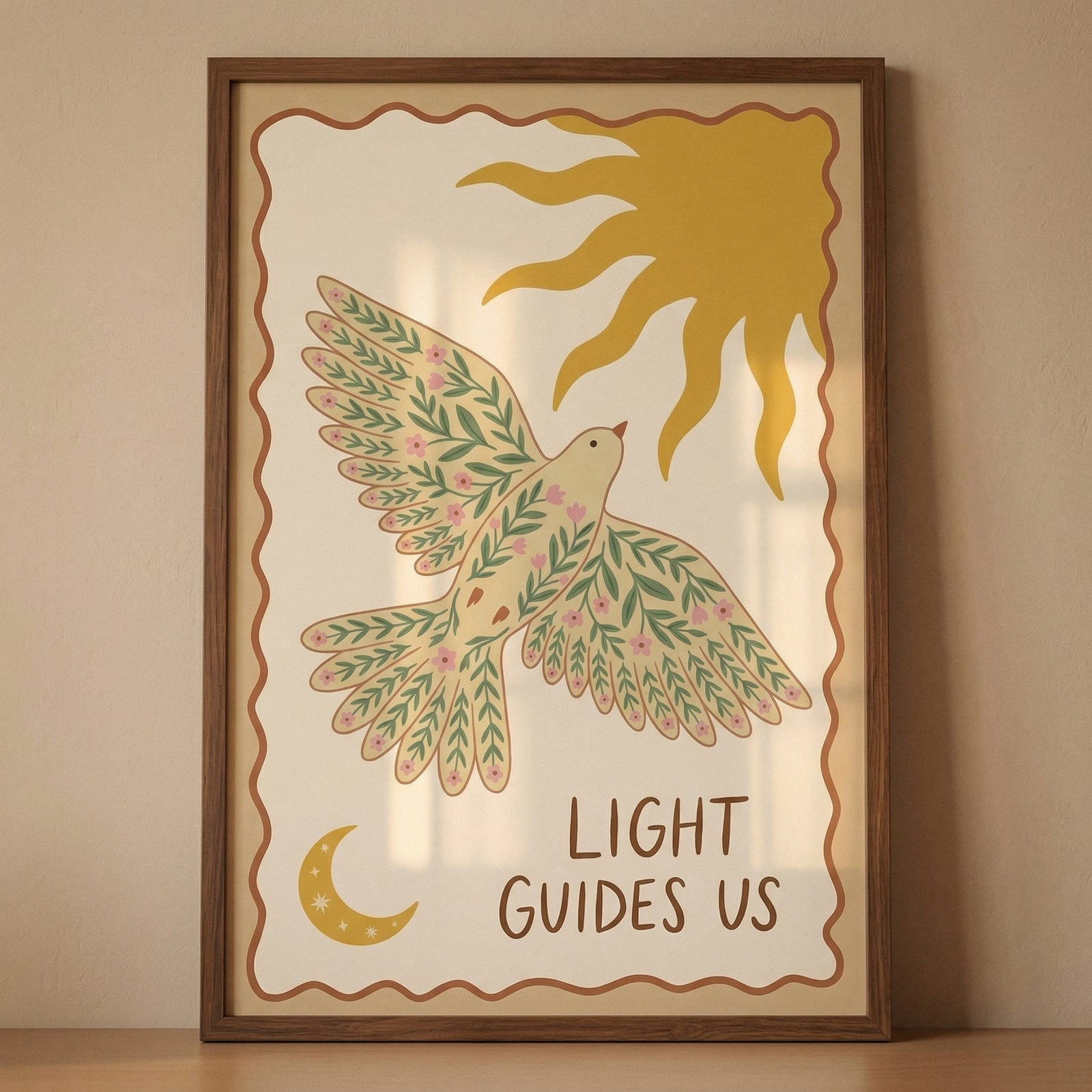 Framed illustration of a bird with wings spread, decorated with green leaves and small pink flowers, flying beneath a stylized yellow sun. The phrase "LIGHT GUIDES US" appears below the bird with a crescent moon in the corner, creating a warm and uplifting decorative print.
