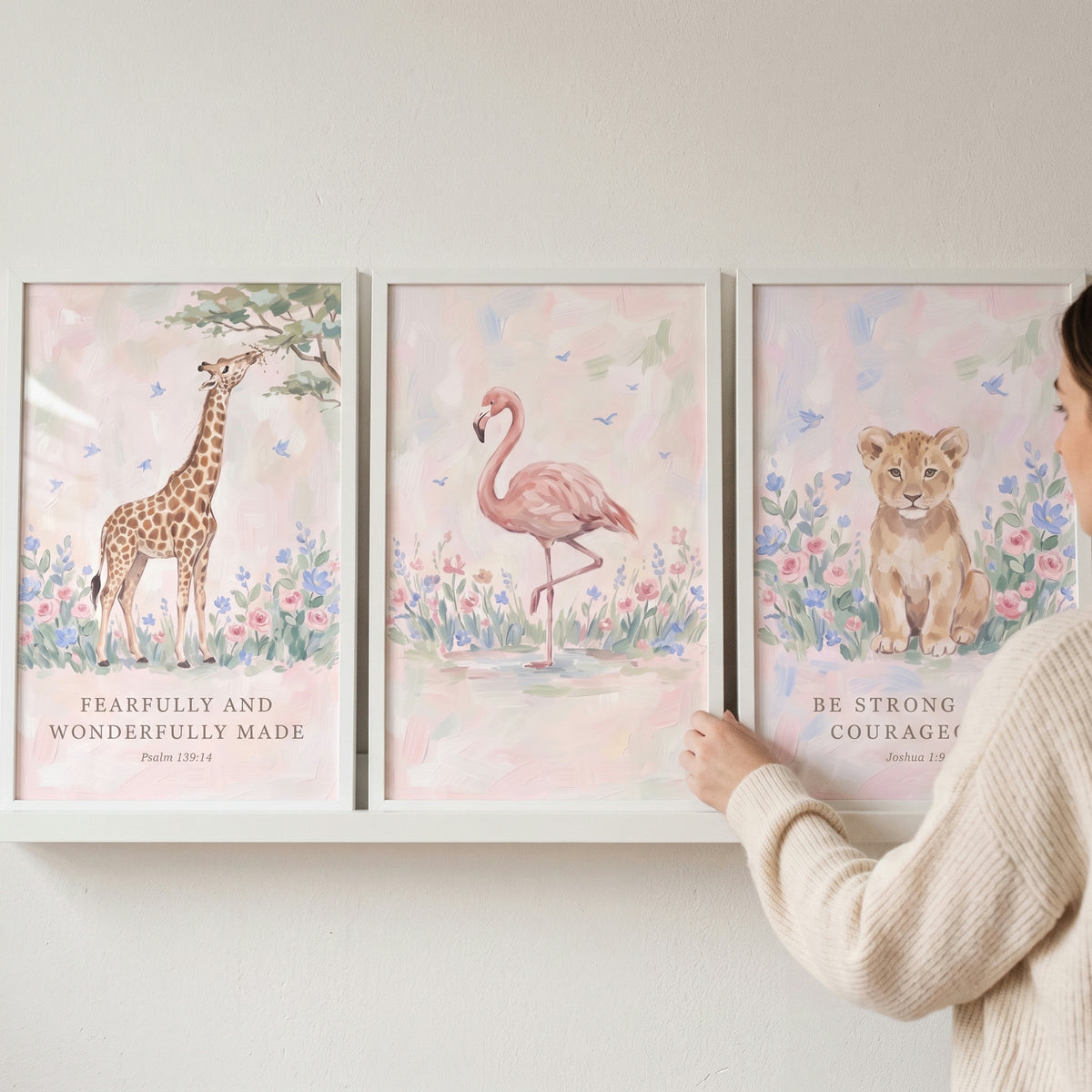 Floral scripture savanna animals wall art set of 3 featuring a giraffe, flamingo, and lion cub on a white shelf.
