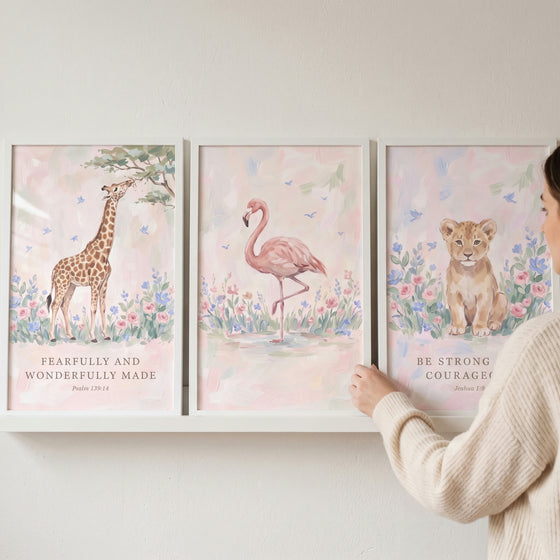 Floral scripture savanna animals wall art set of 3 featuring a giraffe, flamingo, and lion cub on a white shelf.