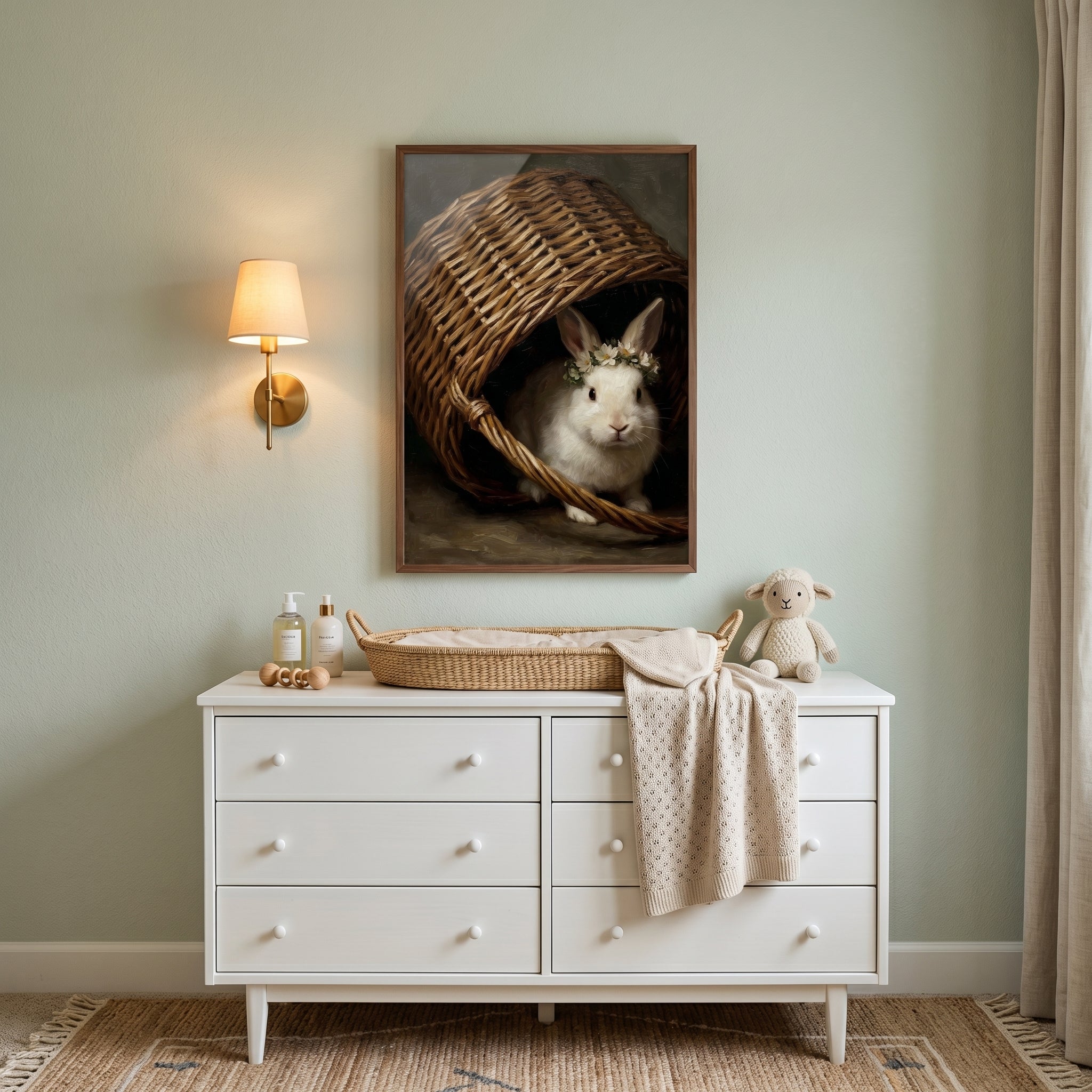 White dresser with changing basket and stuffed lamb below flower crown white rabbit wall art on a light green wall.