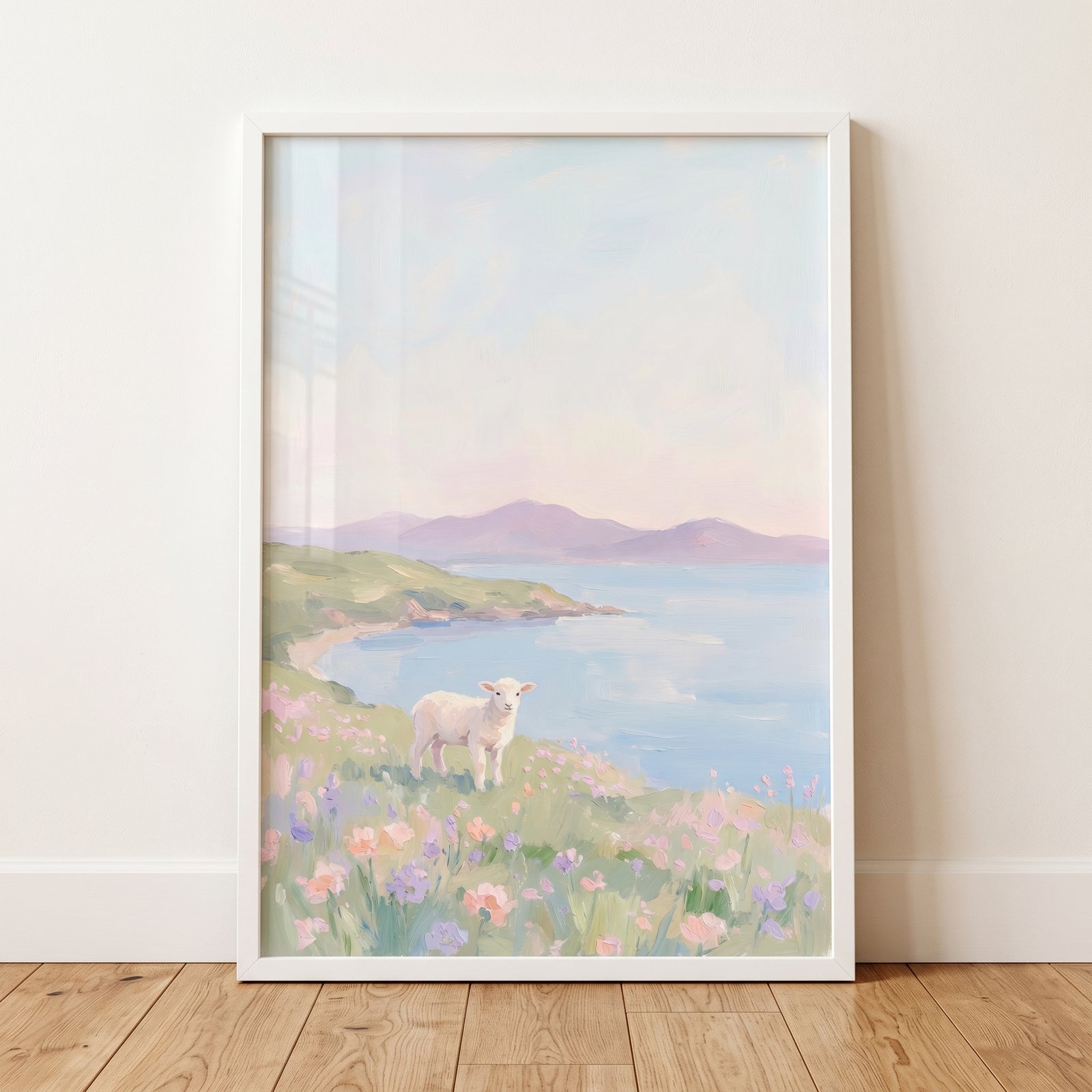 Flower field white lamb wall art in a white frame, showing a lamb in a meadow with pastel mountains and sea.