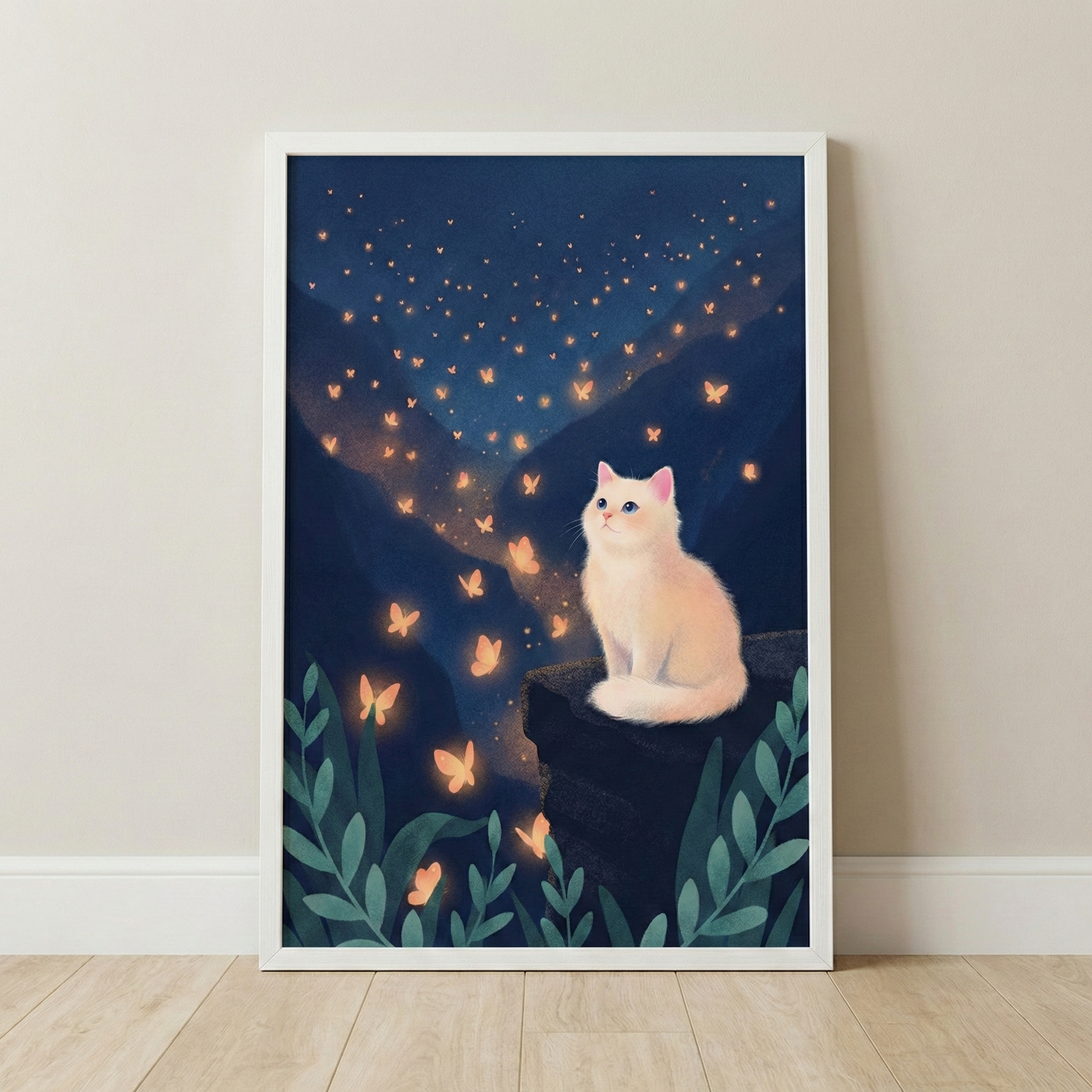 A framed piece of digital art depicts a fluffy white cat sitting on a dark rocky ledge, gazing up at a whimsical night scene. A trail of glowing, golden butterfly-like shapes rises from a valley between dark, silhouetted mountains, ascending toward a starry, deep blue sky. Large, stylized green leaves are arranged along the bottom edge of the composition. The artwork is presented in a white frame, leaning against a light-colored wall above a light wood floor.