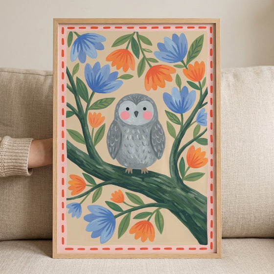 Framed folk floral grey owl wall art features a bird on a branch with blue and orange flowers and a red dashed border.