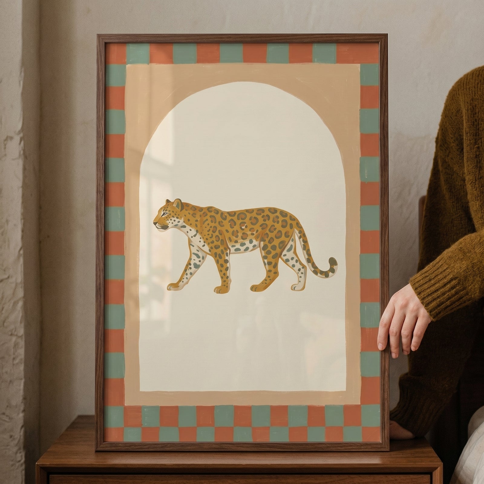 Folk style walking leopard wall art featuring a checkered border and arch in a dark wood frame.