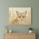 Modern room with a sage green wall and a light wooden dresser. A framed illustration of a fox emerging from golden grass hangs centered above the dresser. A gold vase, ceramic fox, and plant are on the dresser.