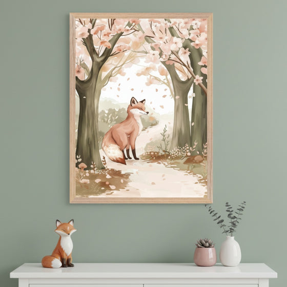 Modern room with a sage green wall and white dresser. A framed watercolor illustration of a reddish-brown fox on a path in a blooming spring forest hangs centered above the dresser.